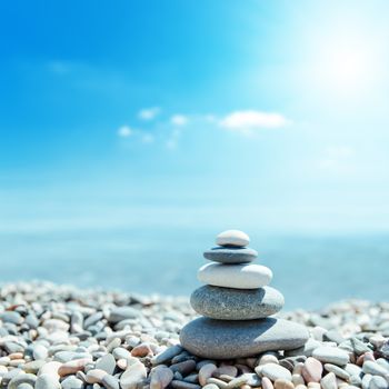 zen-like stones on beach and sun in sky