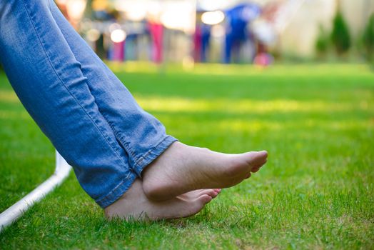 Woman Barefoot Legs on the Green Grass in Garden