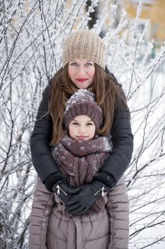 Winter portrait of a nine year girl with her mother