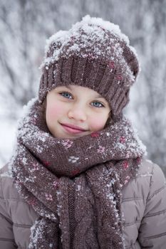 Happy little girl on the background of a winter park