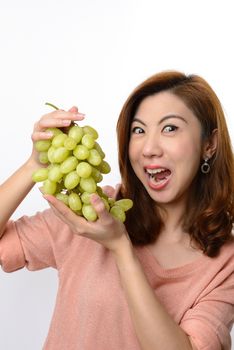 Beautiful asian woman shocked expression while holding grape