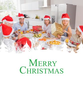 Composite image of smiling family around the dinner table at christmas