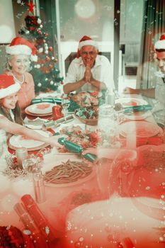Composite image of cheerful family at dining table for christmas dinner