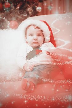 Composite image of cute baby boy on couch at christmas