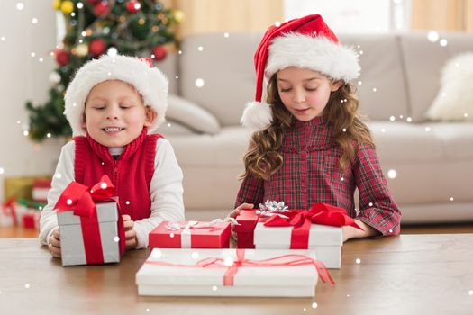 Composite image of festive siblings smiling at their gifts