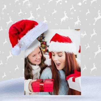 Composite image of festive mother and daughter exchanging gifts