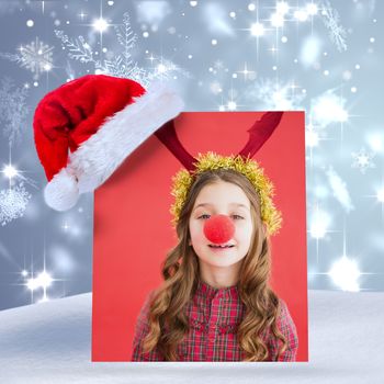 Composite image of festive little girl wearing red nose