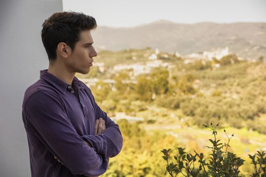 Young man standing looking over a rural landscape