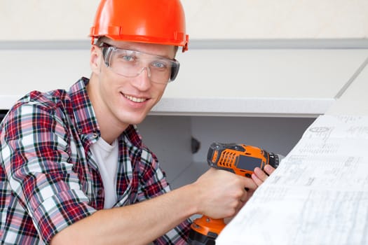 smiling repairman with electric drill