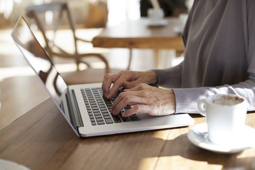 typing laptop in cafe horizontal