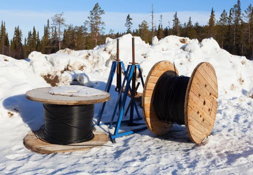 Cable drums prepared for installation in northern snowy forest