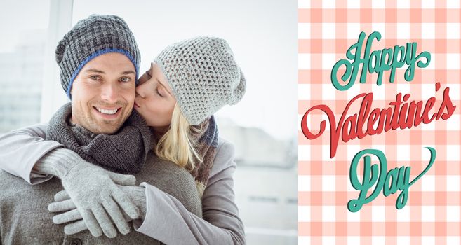Cute couple in warm clothing hugging man smiling at camera against happy valentines day