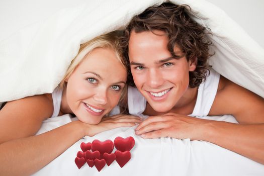 Composite image of couple under a duvet