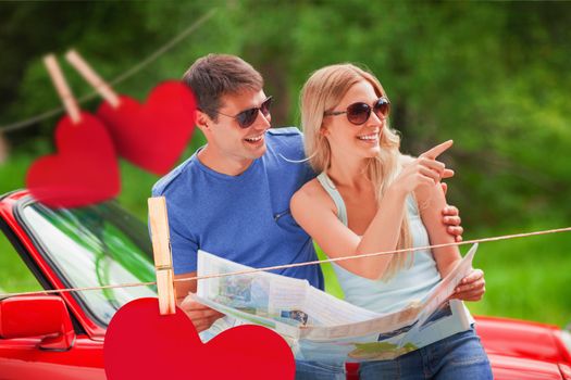Composite image of cheerful young couple reading map