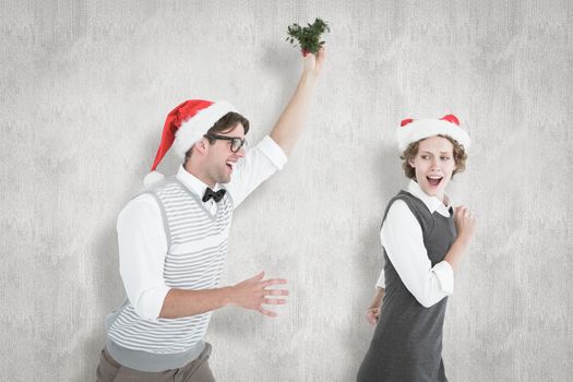 Geeky hipster running away from a man with mistletoe against white background