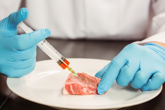Food scientist injecting raw meat