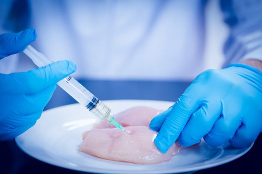 Food scientist injecting raw chicken