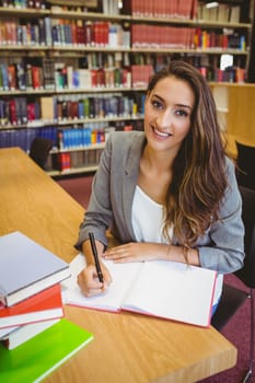 Smiling brunette student doing her assignment