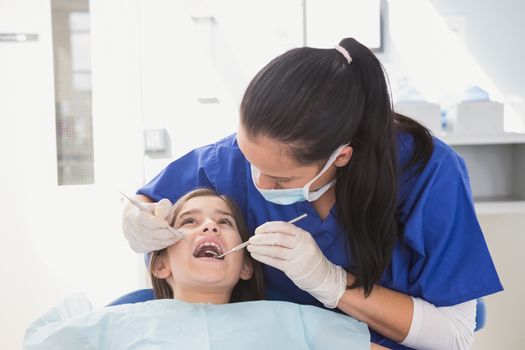 Pediatric dentist using dental explorer and angled mirror 