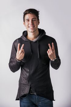 Attractive young man doing peace or victory sign