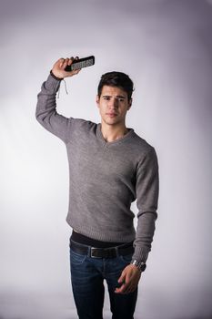 Attractive young man throwing away remote control