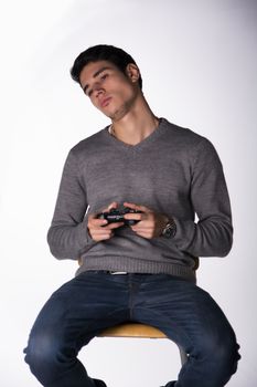 Attractive young man using joystick or joypad for videogames