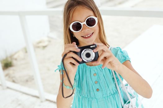 Preteen child resting and taking photos at the beach in summer