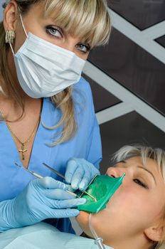 dentist at work with patient, exam, cleaning, curing, using dental water jet