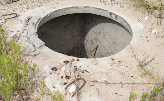 Manhole without cover in the concrete block