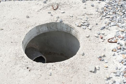 Manhole without cover in new concrete block 
