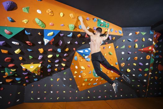 Man practicing bouldering in indoor climbing gym