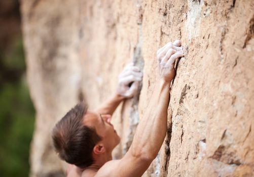 Cropped view of male rock climber on cliff