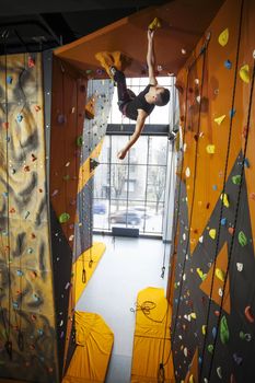 Man practicing top rope climbing in climbing gym