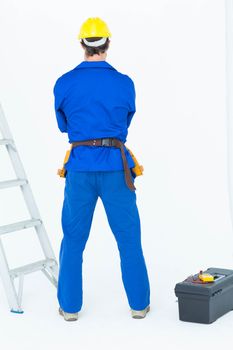 Electrician standing against white background