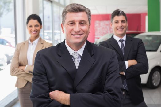 Smiling business team standing with arms crossed
