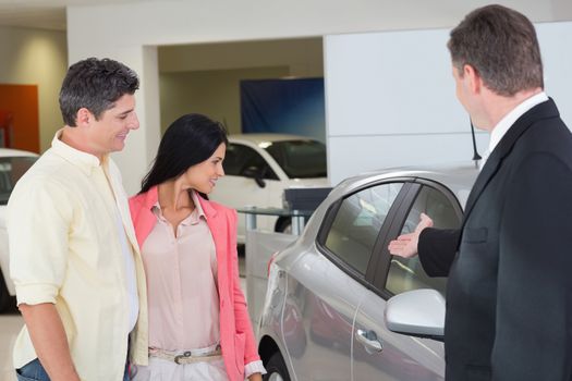 Businessman showing a car to a couple