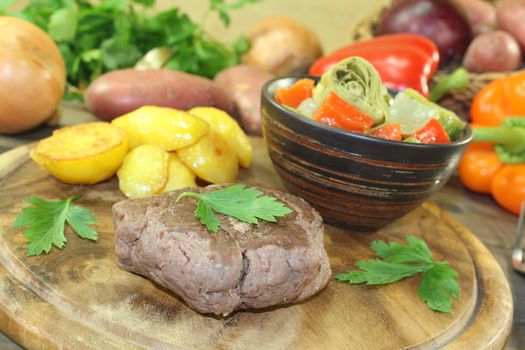 Ostrich steak with crispy baked potatoes and vegetables