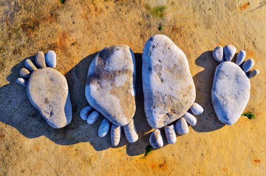 Four stone footprints in the sandy beach