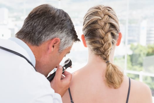 Doctor examining a spot at his patient 