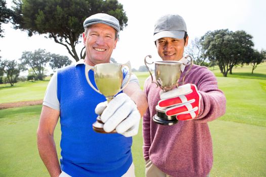 Golfing friends showing their cups 