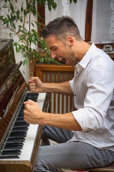 Young man playing classical piano, shouting unhappy and frustrated