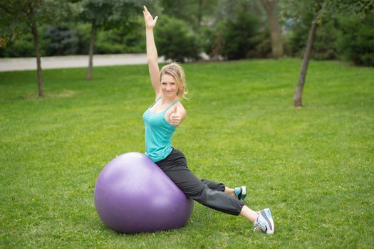 Young happy woman with fitness ball, outdoor