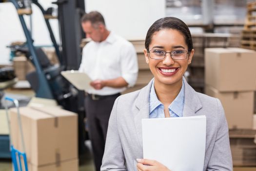 Female manager holding files during busy period