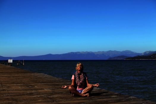 Meditation girl yoga on the beach on Tahoe, California