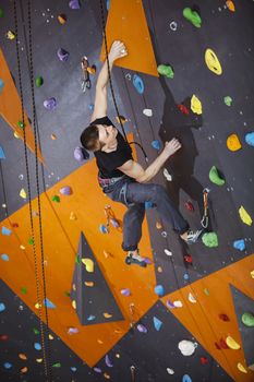Man practicing top rope climbing in climbing gym