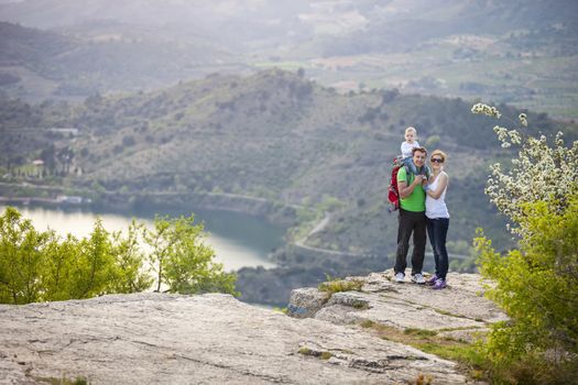 Young couple with toddler boy standing on cliff