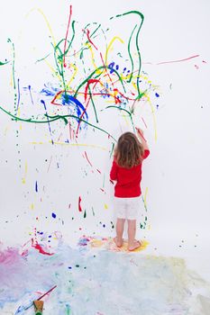 Full Length Shot of a Young Little Kid Painting Something Abstract on White Big Wall Using Different Colors.