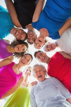 Cheerful people forming huddle at gym