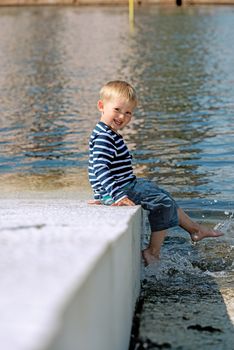 Little preschool boy posing on beach outdoors