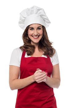 Happy female chef posing with hands clasped